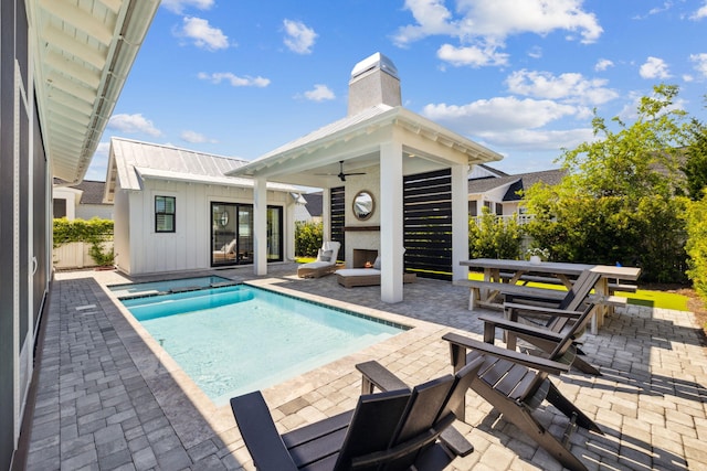 pool with ceiling fan, fence, an outdoor structure, a patio, and a storage structure