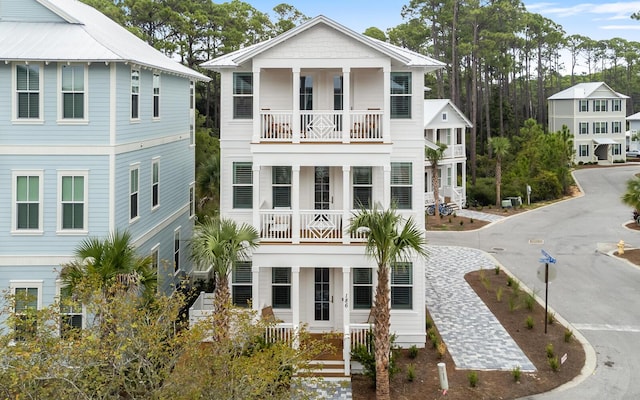 view of front of home with a porch, driveway, and a balcony