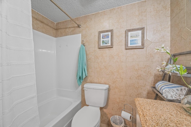 full bath featuring shower / bath combo, tile walls, toilet, and a textured ceiling