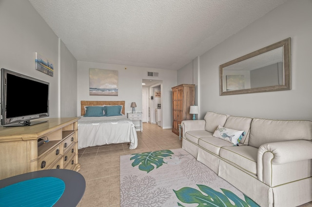 bedroom with light tile patterned floors, visible vents, and a textured ceiling