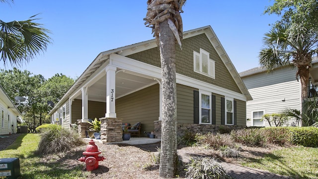 317 Turtle Cv, Panama City Beach, FL 32413 - view of home's exterior with a porch and stone siding