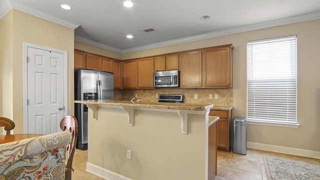 317 Turtle Cv, Panama City Beach, FL 32413 - kitchen with tasteful backsplash, light tile patterned floors, visible vents, a breakfast bar area, and stainless steel appliances