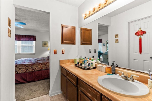 bathroom with vanity, baseboards, ensuite bath, and a textured ceiling