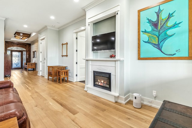1158 Mack Bayou Rd, Santa Rosa Beach, FL 32459 - living area with ornamental molding, baseboards, a glass covered fireplace, and light wood-style floors