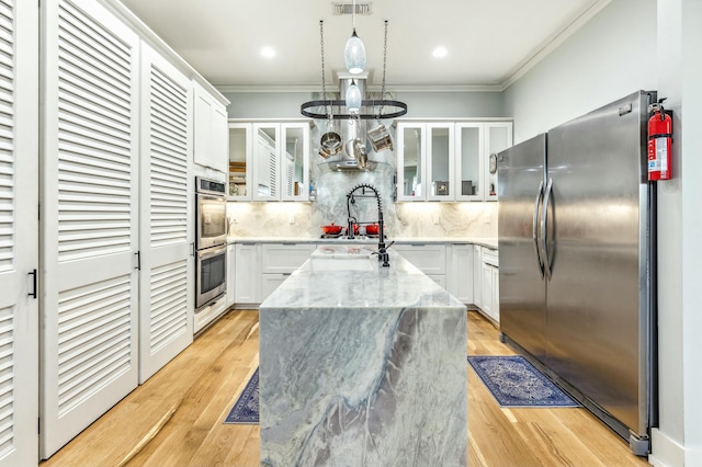 1158 Mack Bayou Rd, Santa Rosa Beach, FL 32459 - kitchen with stainless steel appliances, light stone countertops, a kitchen island with sink, and crown molding