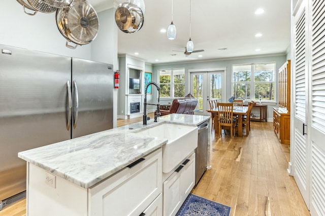 1158 Mack Bayou Rd, Santa Rosa Beach, FL 32459 - kitchen featuring a sink, ornamental molding, appliances with stainless steel finishes, a ceiling fan, and light wood finished floors