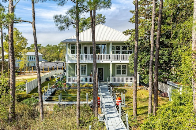1158 Mack Bayou Rd, Santa Rosa Beach, FL 32459 - view of front of property with a balcony, stairway, a fenced front yard, metal roof, and covered porch