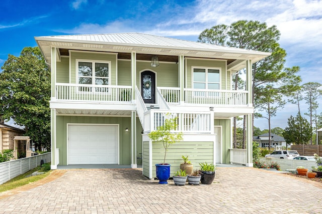 1158 Mack Bayou Rd, Santa Rosa Beach, FL 32459 - raised beach house featuring an attached garage, board and batten siding, covered porch, and decorative driveway
