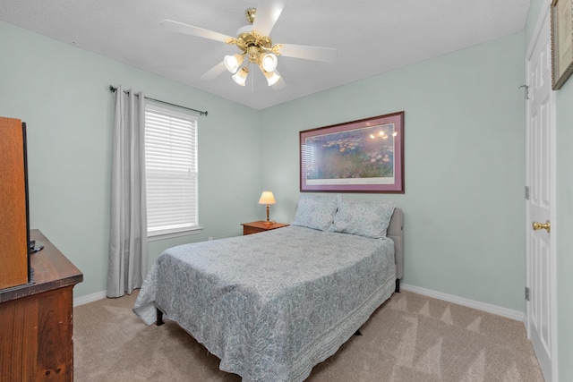 bedroom with light colored carpet, baseboards, and a ceiling fan
