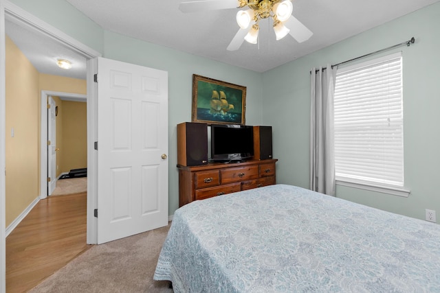 bedroom with light carpet and a ceiling fan
