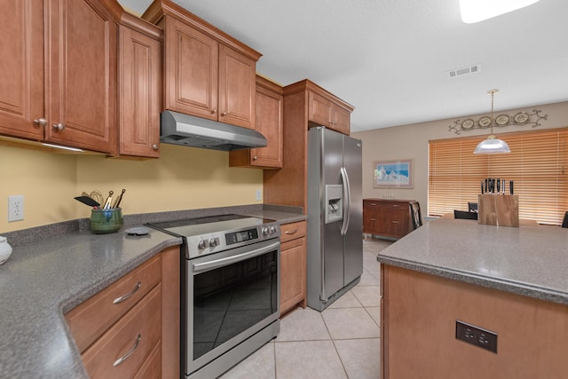 kitchen with light tile patterned floors, dark countertops, appliances with stainless steel finishes, under cabinet range hood, and brown cabinetry