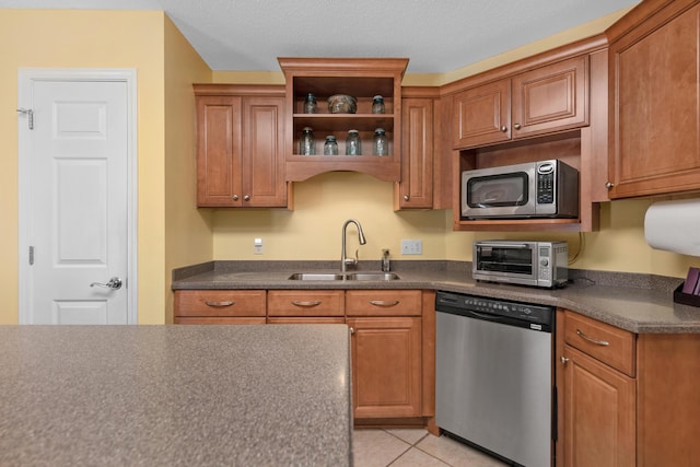 kitchen featuring dark countertops, a sink, a toaster, and stainless steel appliances