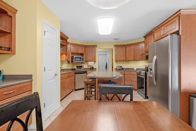kitchen with light tile patterned floors, open shelves, a sink, appliances with stainless steel finishes, and a kitchen island