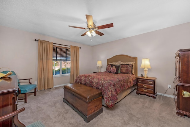 bedroom with light carpet, baseboards, and a ceiling fan