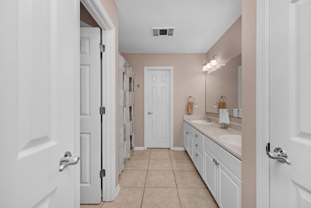 bathroom with tile patterned floors, double vanity, a sink, and visible vents