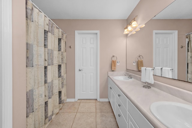 full bathroom with tile patterned floors, double vanity, a sink, and curtained shower