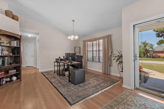 office featuring plenty of natural light, light wood finished floors, a notable chandelier, and vaulted ceiling
