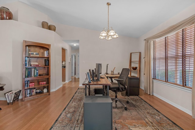 office area with baseboards, wood finished floors, a notable chandelier, and vaulted ceiling