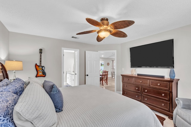 carpeted bedroom with a ceiling fan, ensuite bath, and visible vents