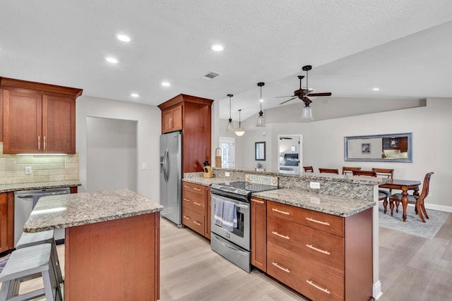 kitchen featuring visible vents, tasteful backsplash, a ceiling fan, light wood finished floors, and appliances with stainless steel finishes