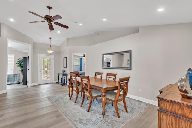 dining area featuring ceiling fan, vaulted ceiling, baseboards, and light wood-type flooring