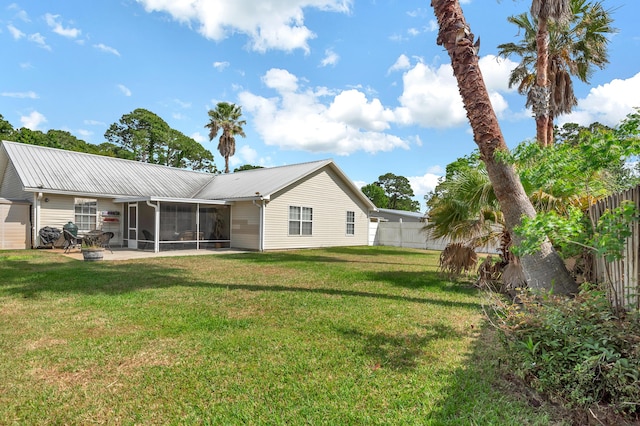 back of house featuring a sunroom, a fenced backyard, and a yard