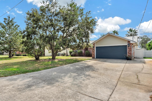 ranch-style home with a front lawn, fence, brick siding, an attached garage, and driveway