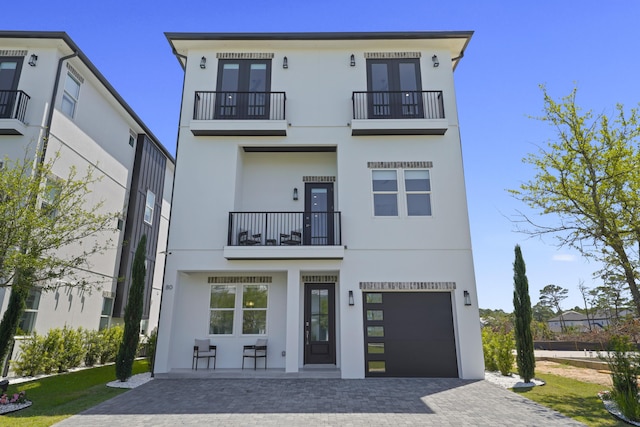 80 Sea Croft Dr, Santa Rosa Beach, FL 32459 - contemporary house with a garage, stucco siding, decorative driveway, a balcony, and french doors