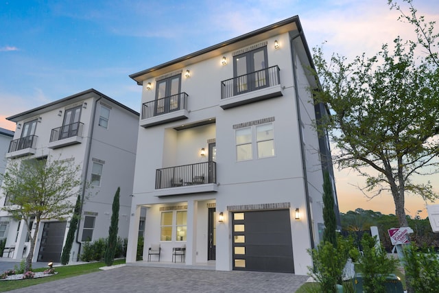 80 Sea Croft Dr, Santa Rosa Beach, FL 32459 - modern home featuring stucco siding, an attached garage, decorative driveway, and a balcony