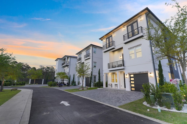 80 Sea Croft Dr, Santa Rosa Beach, FL 32459 - view of front of house featuring decorative driveway, an attached garage, a balcony, and stucco siding