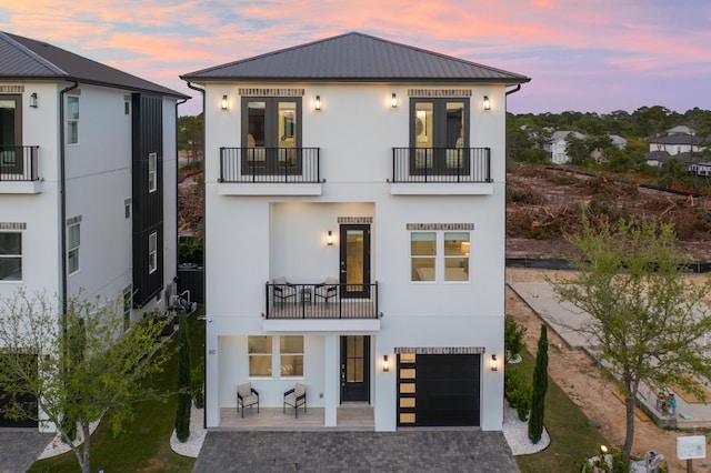 80 Sea Croft Dr, Santa Rosa Beach, FL 32459 - view of front facade with an attached garage, metal roof, a balcony, and stucco siding