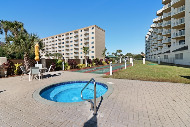 view of swimming pool featuring a yard, fence, and shuffleboard