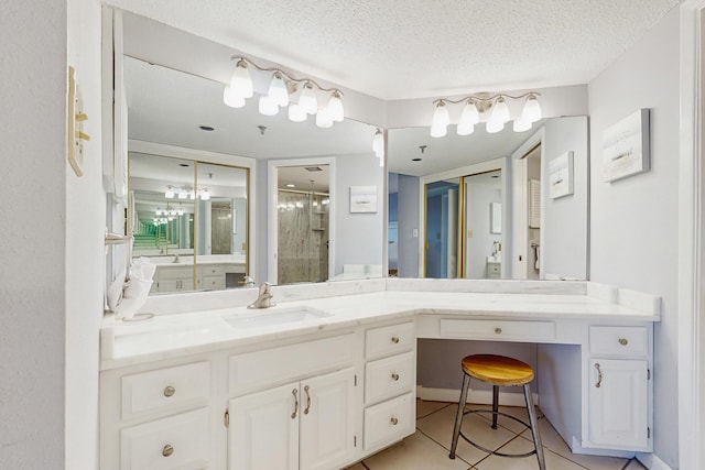 full bath with vanity, a textured ceiling, and a stall shower