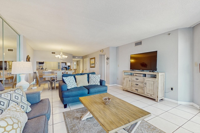 living area featuring visible vents, a textured ceiling, a notable chandelier, and light tile patterned flooring