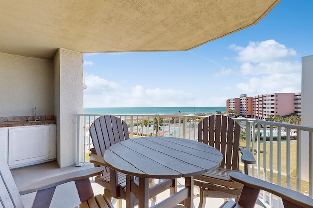 balcony featuring a water view and a sink
