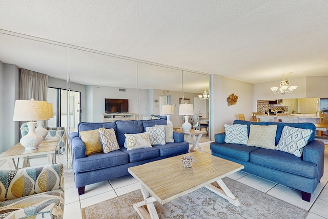 living area with light tile patterned floors, an inviting chandelier, visible vents, and a textured ceiling