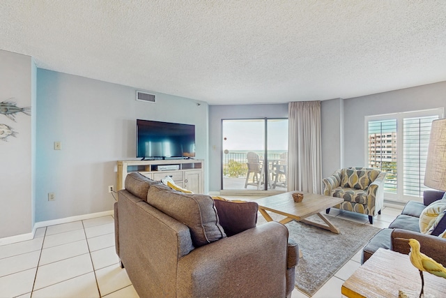 living area featuring visible vents, light tile patterned floors, and a textured ceiling