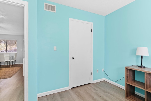 bedroom with visible vents, baseboards, and wood finished floors