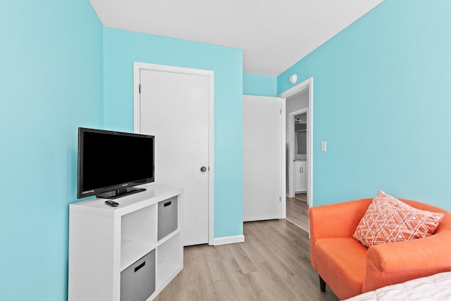 living area with baseboards and light wood finished floors