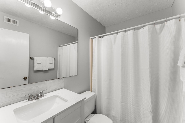 bathroom featuring vanity, visible vents, a textured ceiling, and toilet