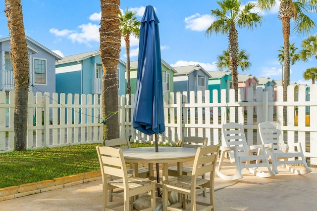 view of patio featuring a residential view, outdoor dining space, and fence