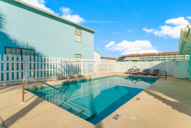 pool with a patio and a fenced backyard