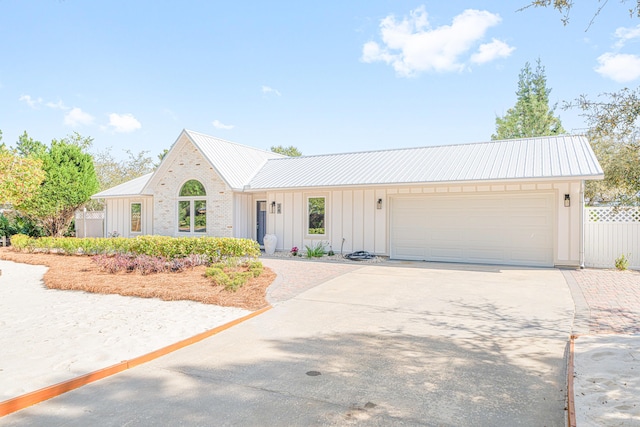 34 Debbie Ln, Santa Rosa Beach, FL 32459 - view of front of house with board and batten siding, driveway, a garage, and metal roof