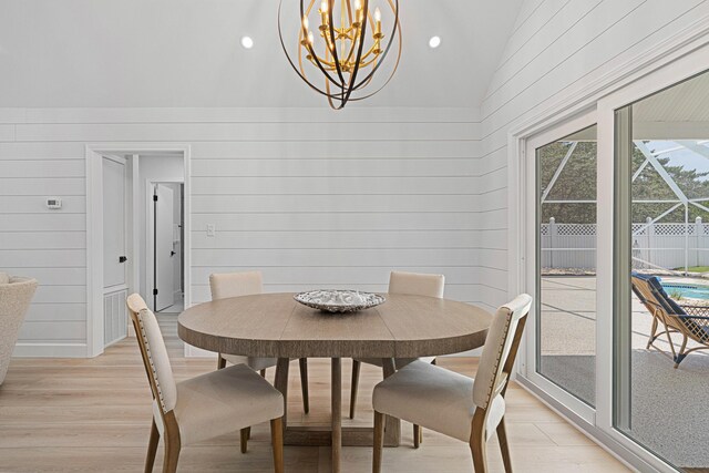 34 Debbie Ln, Santa Rosa Beach, FL 32459 - dining area featuring light wood-type flooring, vaulted ceiling, a chandelier, and wooden walls