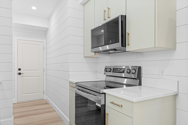 34 Debbie Ln, Santa Rosa Beach, FL 32459 - kitchen featuring appliances with stainless steel finishes, light wood-type flooring, white cabinetry, recessed lighting, and wood walls