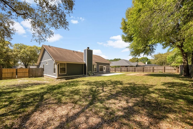 4651 Browning Ct, Crestview, FL 32539 - back of property with a patio area, a fenced backyard, a lawn, and a chimney