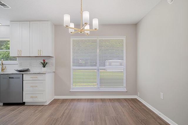 2899 Wisteria Ave, Crestview, FL 32539 - kitchen featuring dishwasher, a chandelier, white cabinets, light wood-type flooring, and baseboards