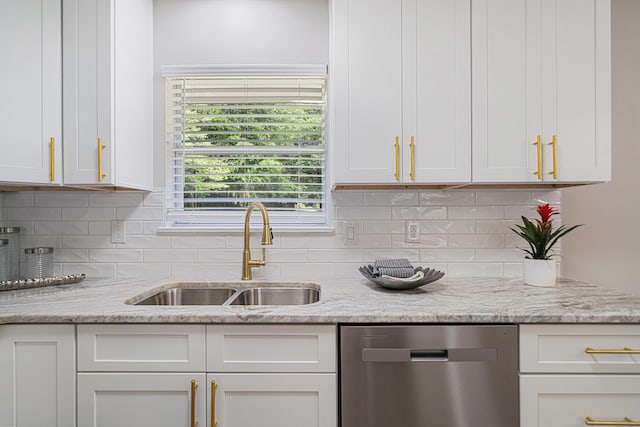2899 Wisteria Ave, Crestview, FL 32539 - kitchen with stainless steel dishwasher, a sink, white cabinetry, backsplash, and light stone countertops