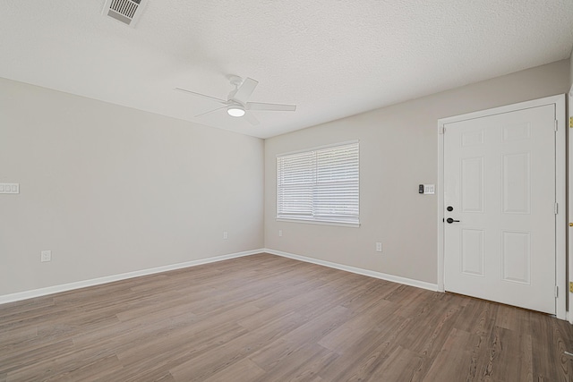 2899 Wisteria Ave, Crestview, FL 32539 - spare room with wood finished floors, ceiling fan, baseboards, and a textured ceiling