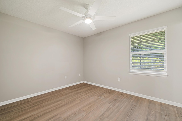 2899 Wisteria Ave, Crestview, FL 32539 - empty room with light wood finished floors, baseboards, a ceiling fan, and a textured ceiling